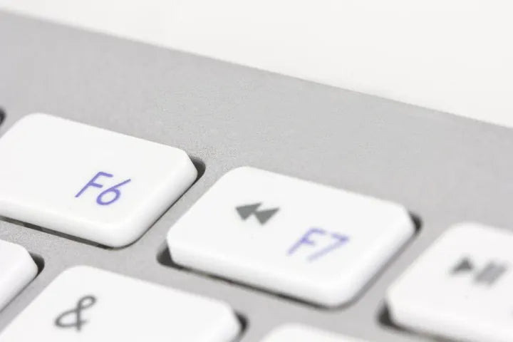 Close-up of a computer keyboard with F6 and F7 keys highlighted