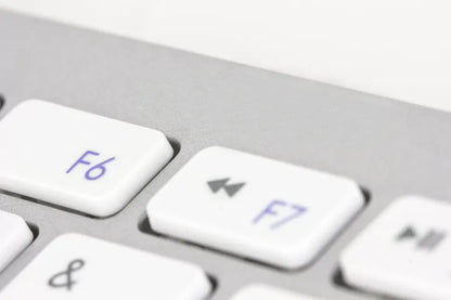 Close-up of a computer keyboard with F6 and F7 keys highlighted
