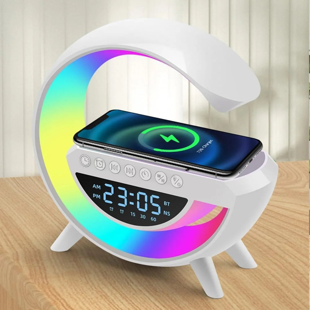 White moon-shaped clock with digital display and smartphone charging pad on a wooden surface.
