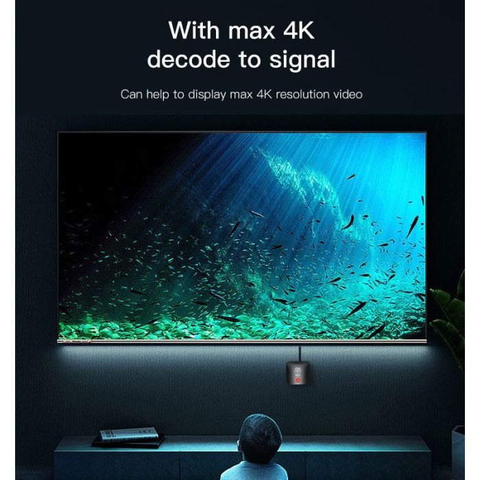 Person watching a large screen displaying an underwater scene with text about 4K resolution.