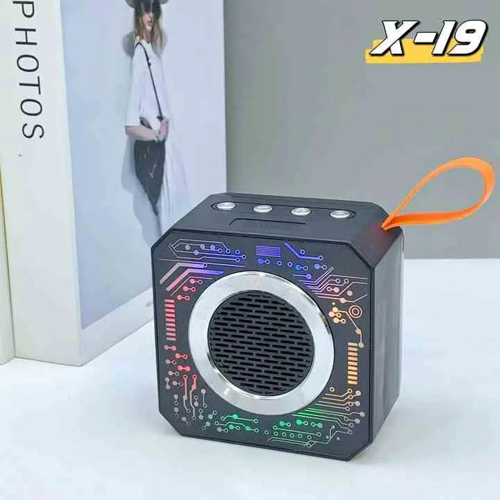 Black portable speaker with colorful circuit design on a white surface, featuring the brand 'X-19'.