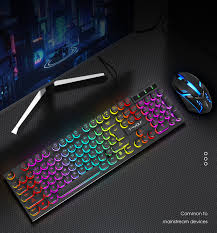 Colorful gaming keyboard on a dark surface with a monitor in the background