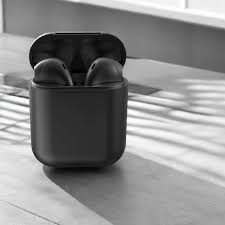 Black wireless earbuds in a charging case on a wooden surface
